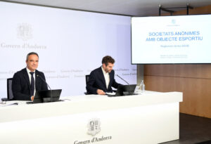 Dos hombres sentados ante una mesa durante una presentación sobre sociedades anónimas deportivas en Andorra.